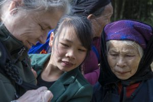 Tay-kvinder ser billeder af sig selv ved Ban Gioc