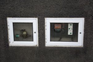 Målere til aflæsning af ell og vand sidder synligt fra gaden i mange bygninger.